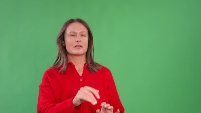 Woman demonstrating sign language gestures in front of green screen for learning purposes