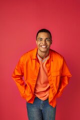 Fototapeta premium Vibrant young man expresses joy in colorful attire against bright background