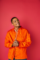 Vibrant young man exuding joy in bright attire against a colorful background