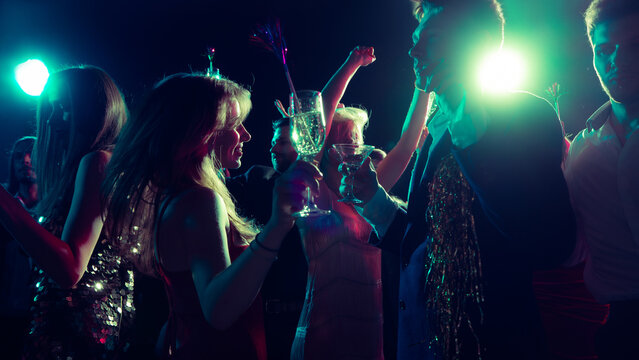 Joyful Christmas night with friends dancing and clinking glasses. Concept of holiday campaign visuals, event marketing, party fashion, and youth energy