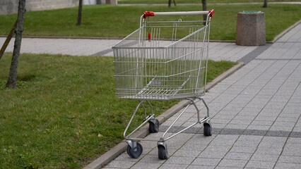 Empty shopping cart on city sidewalk