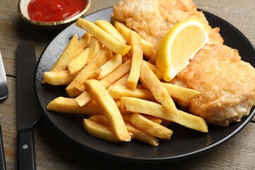 British Traditional Fish and chips served on wooden table, closeup