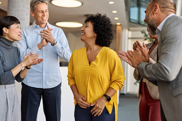 Portrait of a businesswoman celebrating during a meeting in office, group of businesspeople...