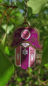 The hamsa hand is on a tree branch outdoors. Popular motif in Jewish jewelry. Middle Eastern protective amulet hand and eye. Traditional talisman. Faith and protection. Religious symbol