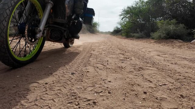 Motorcycle rides on a dirt road, conveying adventure and freedom