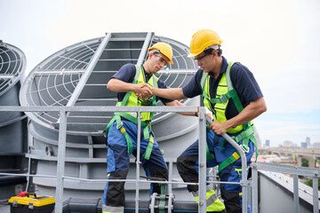 Construction workers collaborating on a building's rooftop while wearing safety equipment,...