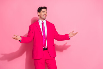 Charismatic man in vibrant pink suit posing confidently against pastel background, exuding style, charm, and cheerful energy