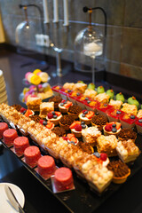 Various colorful desserts with berries, chocolate, and cream on display, a delicious sweet collection of pastries.