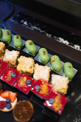 Various colorful desserts with berries, chocolate, and cream on display, a delicious sweet collection of pastries.