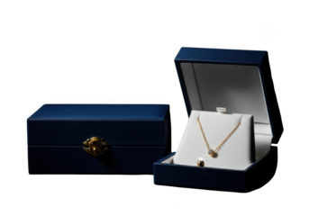 Elegant gold necklace with a green gemstone in a blue jewelry box isolated on transparent background
