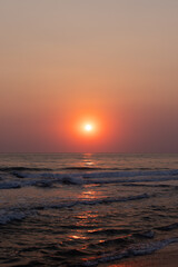 Fototapeta premium A tranquil sunset over the sea, painting the horizon with warm orange and pink colors