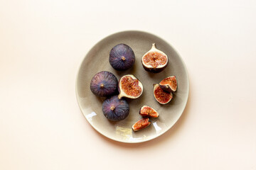Fresh ripe figs on a plate top view on a stone background