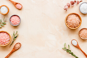 Fototapeta na wymiar Beauty spa therapy cosmetics and wellness flat lay - sea salt in many bowls with flowers, top view