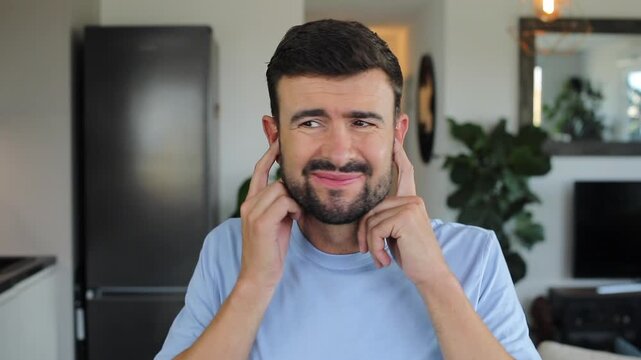 Stressed out man using ear plugs to stop the noise 