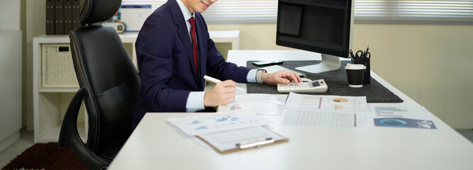 businessman hand working with finances about cost and calculator and computer on desk in modern office