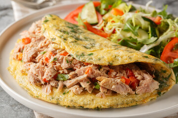 Breakfast Omelet with canned tuna and fresh vegetables salad closeup on the plate on the table. Horizontal
