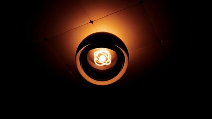 Glowing atom shaped light bulb illuminating ceiling