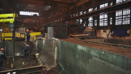 Foundry workers pouring molten metal in a mold. Stock clip