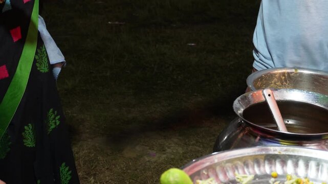 A person served popular Indian street food snack in paper cup. It is known golgappa and phuchka. 