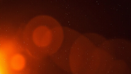 Cinematic dark background with warm orange lens flare and vintage film grain texture, featuring subtle dust particles. Ideal for retro video overlays, photography effects, and graphic design.