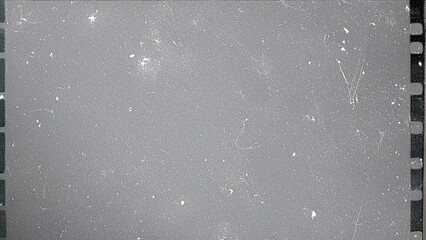 Vintage film grain texture with dust, scratches, and film perforations, a gray retro cinematic overlay for photography effects, video projects, and digital graphic design.