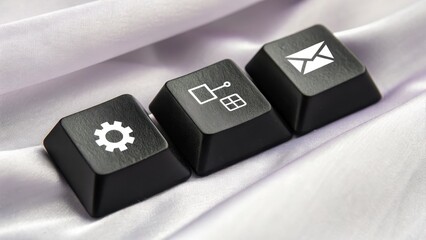 Three computer keyboard keys with icons for settings network and email on a satin background