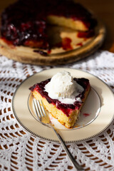 Homemade plum pie with ice cream ball on handmade white lace napkin