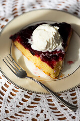 Homemade plum pie with ice cream ball on handmade white lace napkin