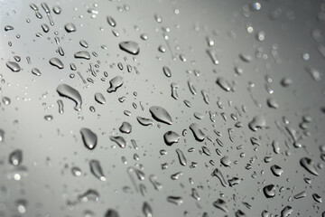 Calm abstract background of wet gray surface texture with water drop and droplet from rain. This peaceful view shows clear liquid condensation on shiny metallic pane
