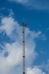 Obraz premium High steel tower with mobile phone antenna and radio equipment against a blue sky for wireless cellular communication network