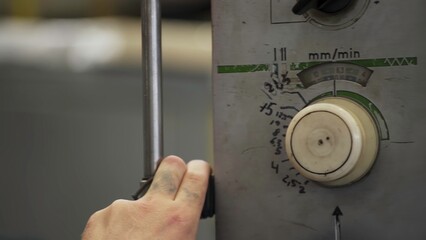 Worker adjusting speed and feed rate on industrial machine control panel. Stock clip