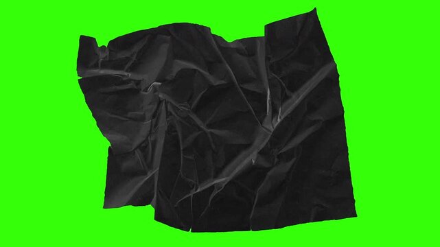 Stop motion animation of ripped black crumpled craft paper revealing a green screen hole. Perfect for creative title transitions, intros, or visual effects in handmade organic style.