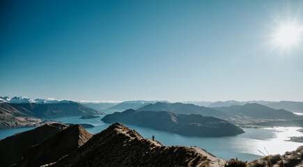 Hiker Standing on Roys Peak Viewpoint Overlooking Lake Wanaka and Southern Alps, New Zealand