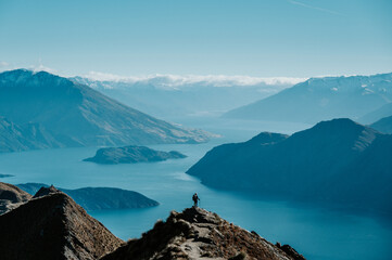 Hiker Standing on Roys Peak Viewpoint Overlooking Lake Wanaka and Southern Alps, New Zealand