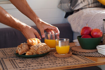healthy lifestyle, van life. hands of a man serving breakfast at the table of a motorhome