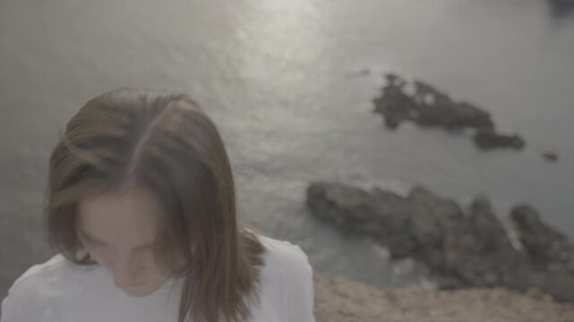 Medium shot of woman looking at ocean from cliff in Madeira island Portugal (SLOG3)