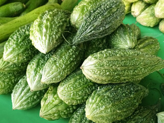 Fresh Green Bitter Melon in Bulk at Outdoor Market, High-Quality Organic Bitter Gourd Vegetable Close-Up View