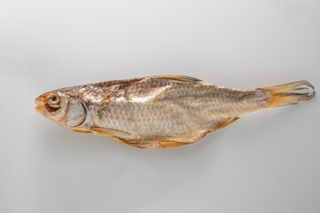 Dried fish showcasing preserved texture and color on a neutral background - taranka