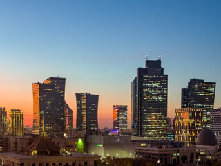 Naklejka premium Sun is setting in the backround of city buildings