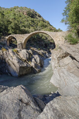 Stone arch bridge in mountains, Alps, Italy