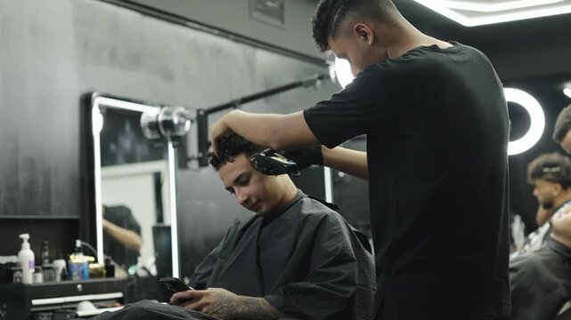 Barber giving client a haircut in a modern barbershop