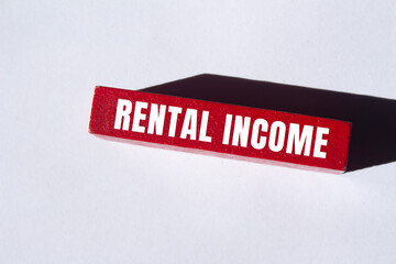 Rental income message written on wooden block background. Conceptual Rental income symbol. Copy...