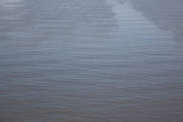Calm river surface displaying gentle ripples under natural light
