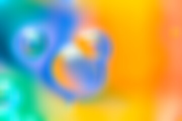 Vivid blurred abstract background with colorful blue, green, yellow and orange gradients. Soft shapes and smooth transitions create a dynamic, cheerful atmosphere. copy space