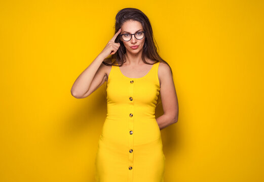 Crafty young woman asking. Copy space, isolated on yellow background. Close-up girl at ask concept.