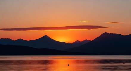 Fototapeta premium Tranquil mountain silhouettes meet the vibrant embrace of a breathtaking sunset at lakeside