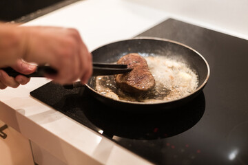 the process of cooking beef steak in a frying pan