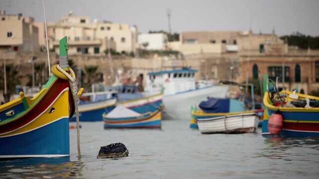 Traditional Luzzu fishing boats anchored in the colourful harbour of Marsaxlokk, Malta. A charming and iconic scene of island life and maritime heritage.