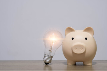 Piggy bank with glowing light bulb beside it represents smart saving ideas, creative financial planning, innovation in budgeting, and intelligent money management concepts.
