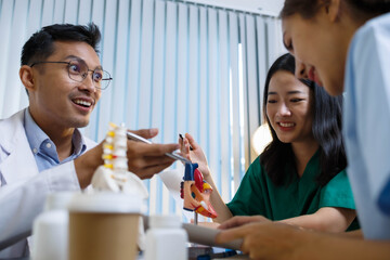 A doctor and a nurse are examining a model of a heart. The doctor is explaining the anatomy of the heart to the nurse
